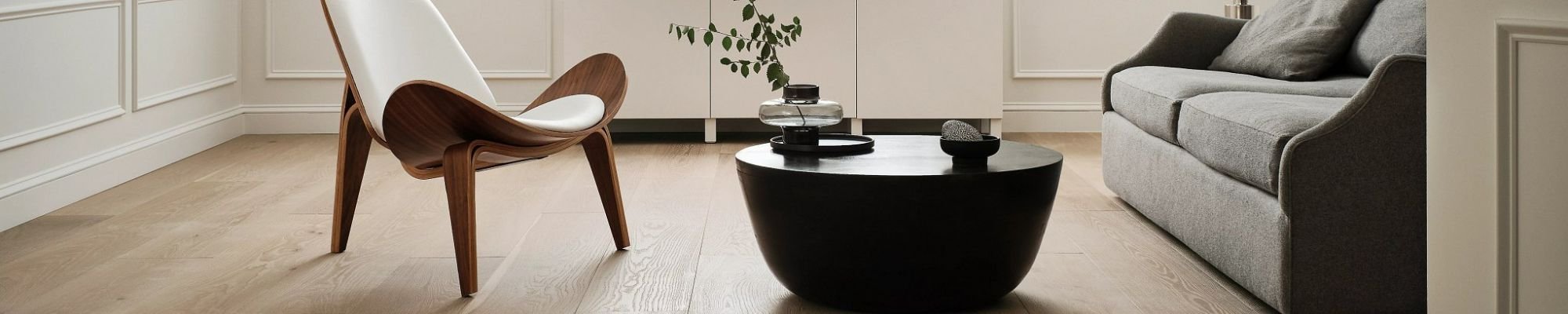 Living room with a sofa and armchair and hardwood flooring from River City Flooring in Missoula, MT